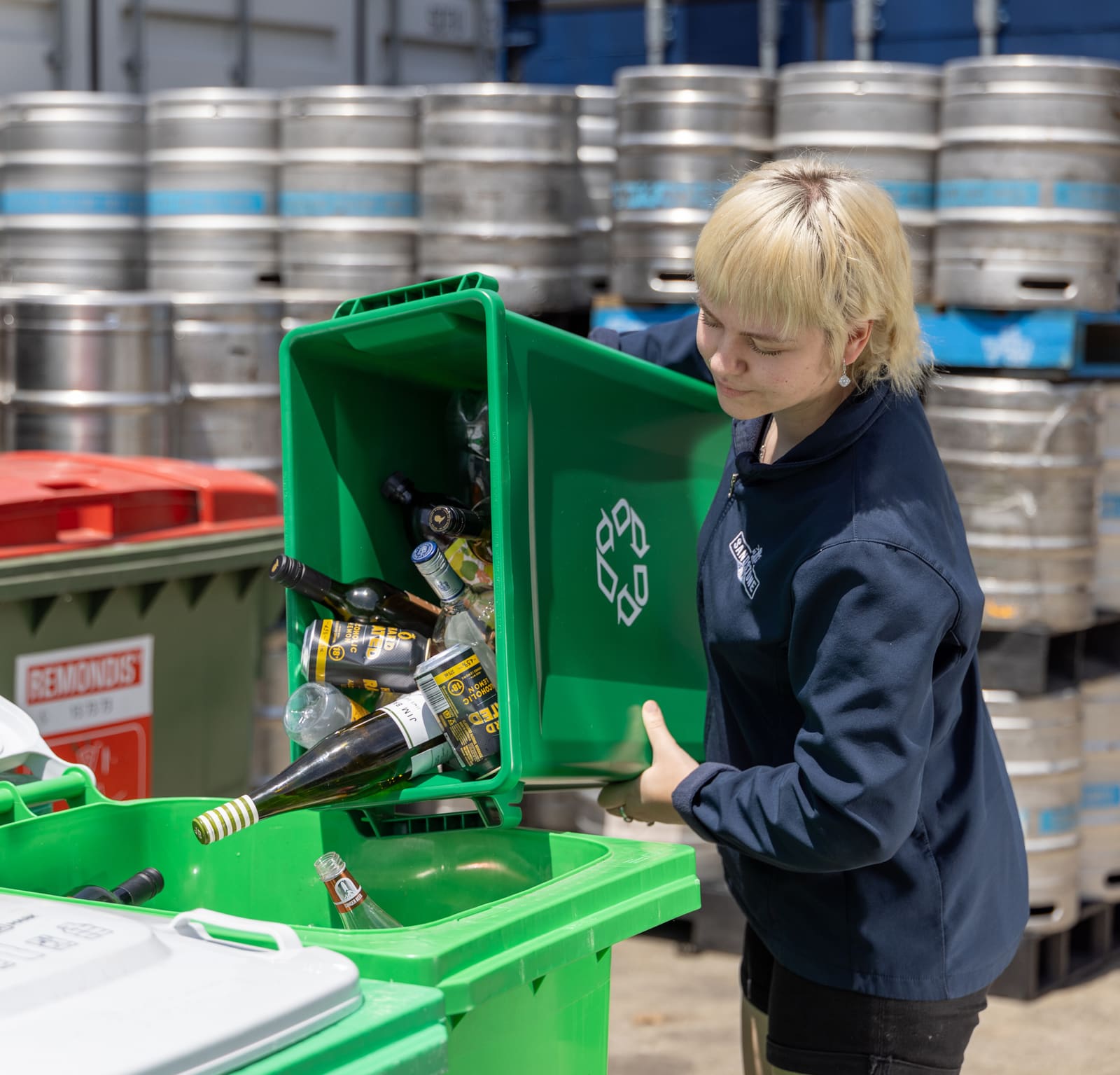 A collection team member emptying eligible drink containers from a commercial bin.