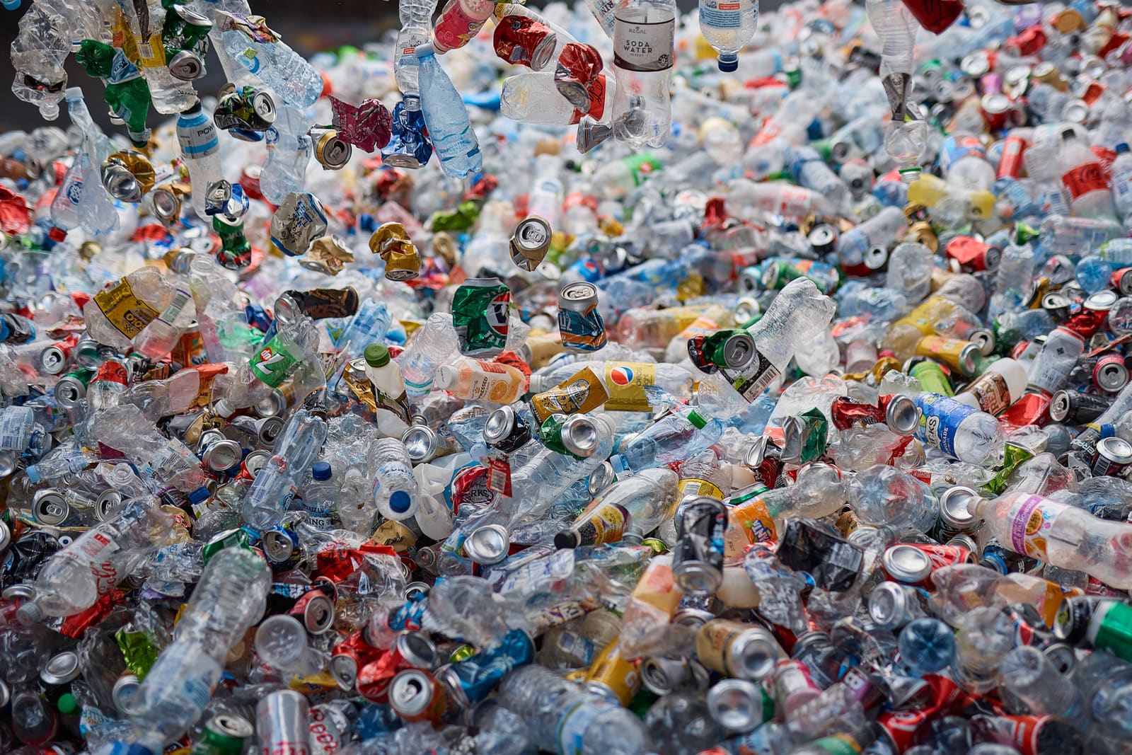 A mix of eligible bottles and cans ready for sorting by material type.