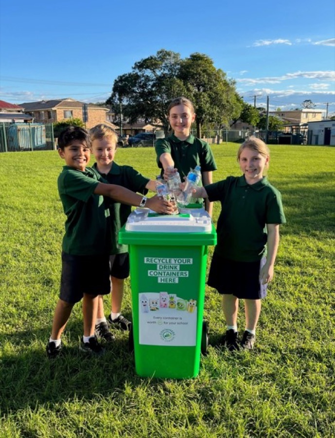 Students standing near a Containers for Change school collection bin.